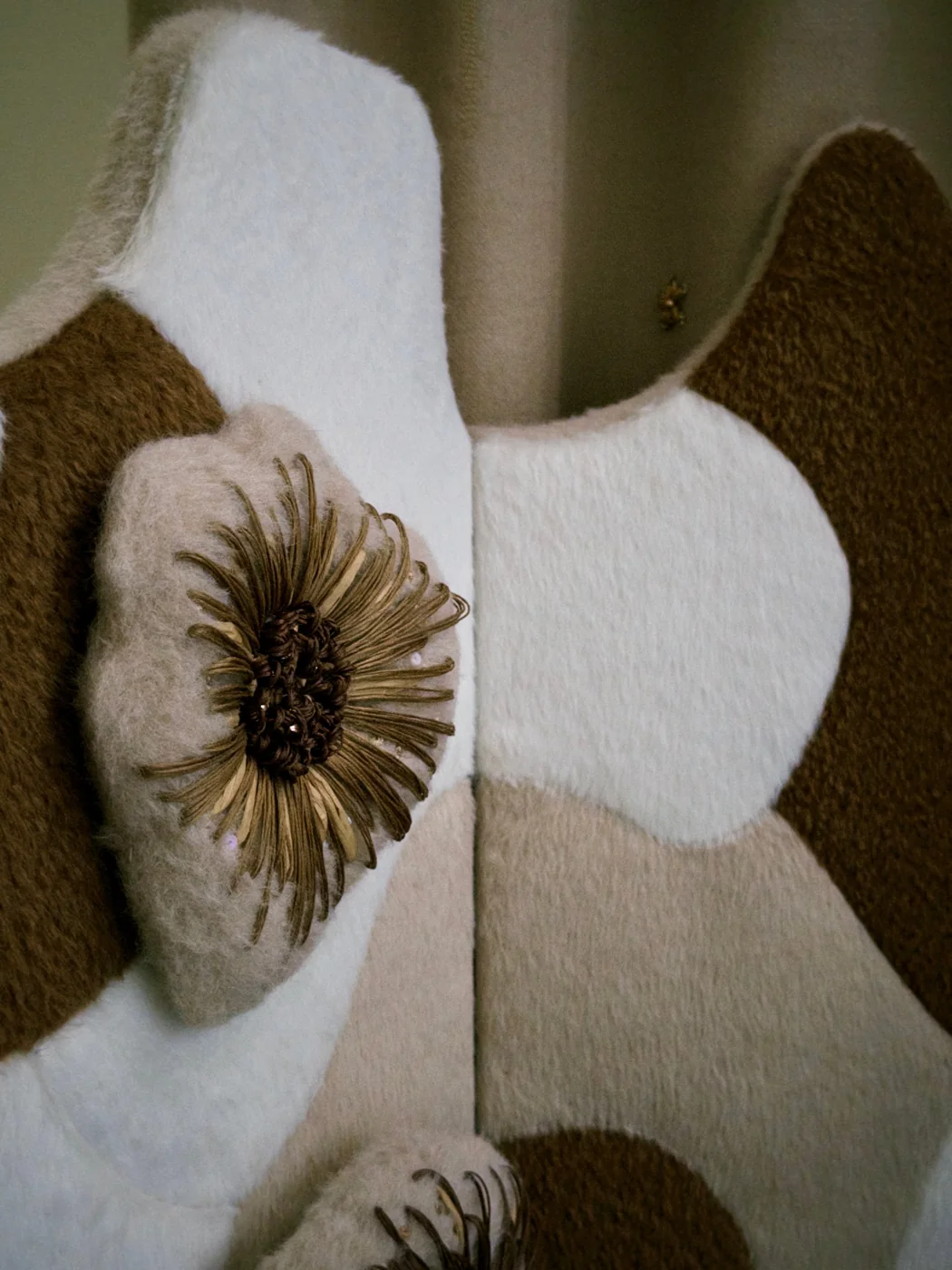 Fleur brodée en relief sur des panneaux de laine ivoire, beige et brun